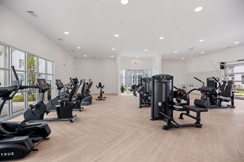 a spacious fitness room with cardio machines and weightsat Oak Grove at Blake Farm, Wilmington, NC